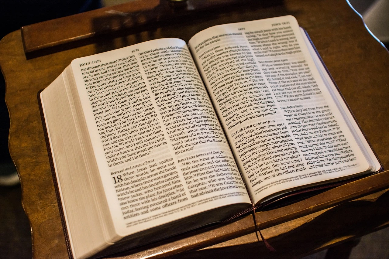 Manuscrit ancien ouvert avec texte biblique manuscrit, représentant les documents sources originaux derrière les traductions modernes