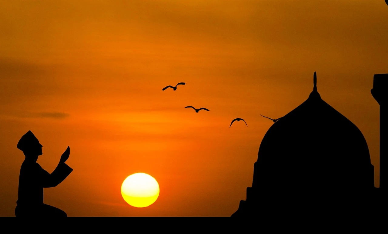 Person in quiet prayer at sunrise, hands folded, light filtering through a window — representing a daily prayer practice